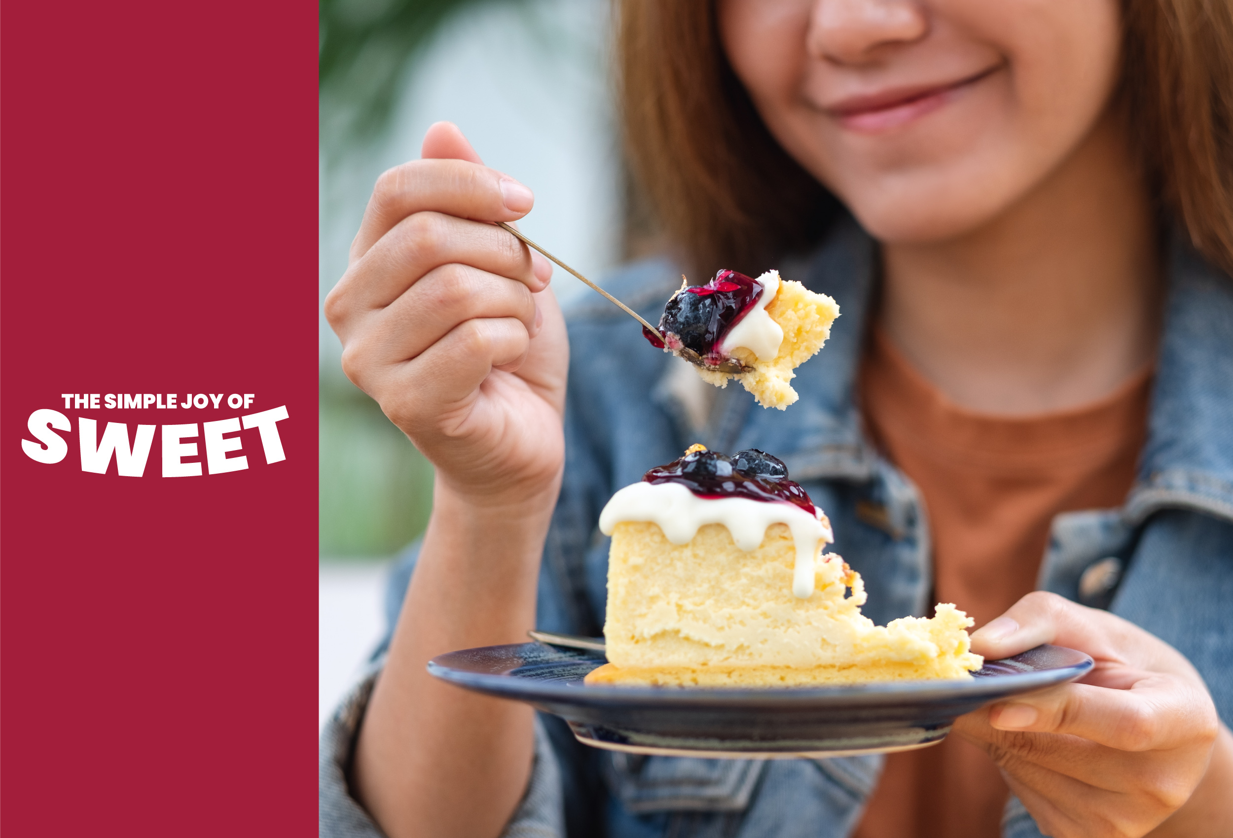 Woman-eating-a-delicious-cake-with-mixed-berry-toppers-and-vanilla-icing